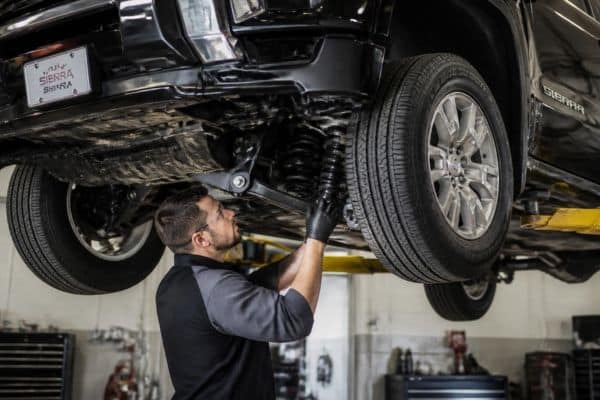 Mechanic checking GMC Sierra 1500 suspension in Apopka, FL